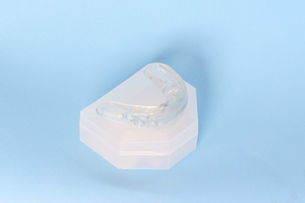Clear dental night guard on a model of upper teeth for bruxism treatment.