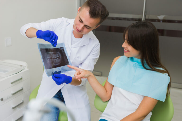 male dentist shows a female patient an x-ray